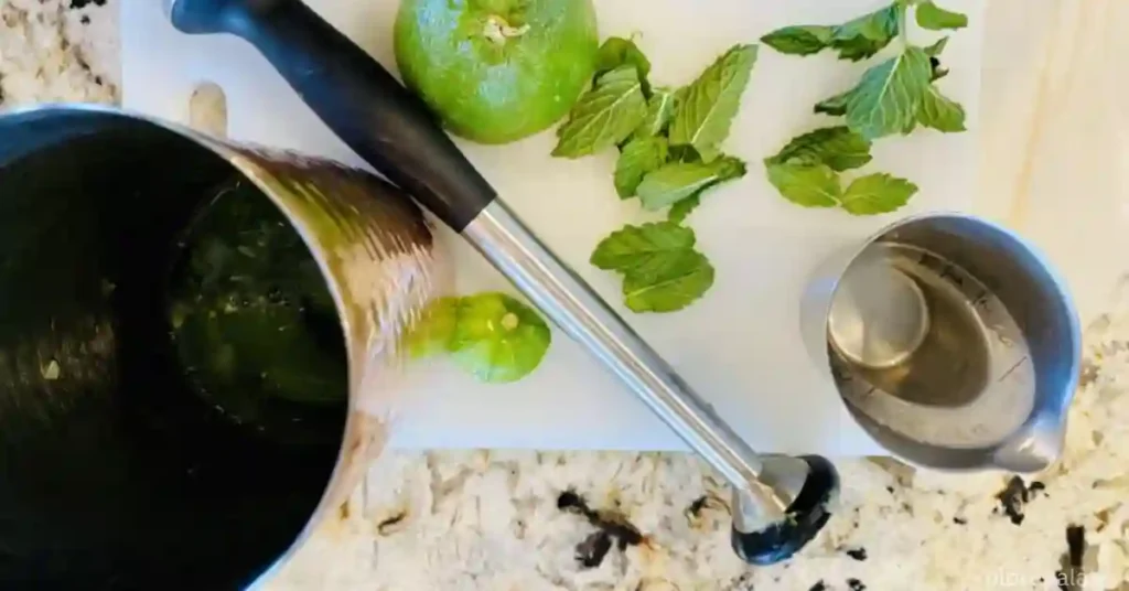 Start by placing a few cucumber slices and mint leaves into a cocktail shaker.